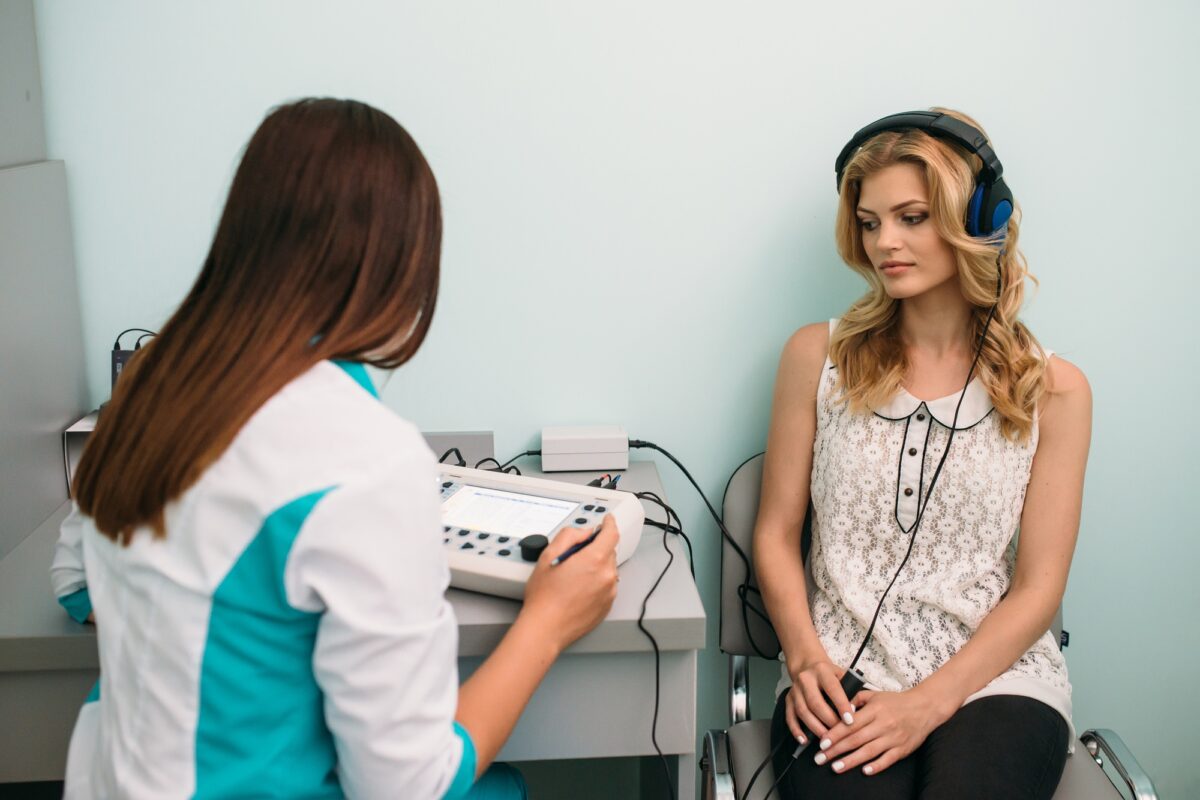 Audiologiste effectuant un test auditif avec un patient dans un environnement clinique