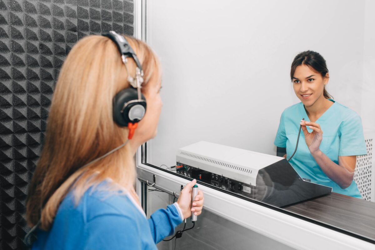 audiologiste effectuant un test auditif dans une salle audio spéciale