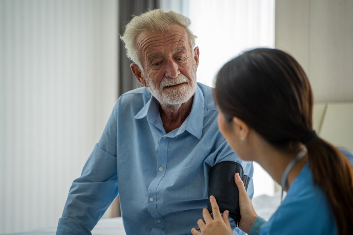Des infirmières s'occupent d'un homme âgé à domicile, concept de service d'assurance médicale.