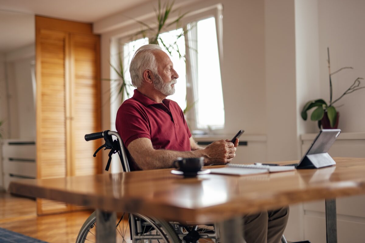 Homme handicapé d'âge mûr, perdu dans ses pensées, chez lui.