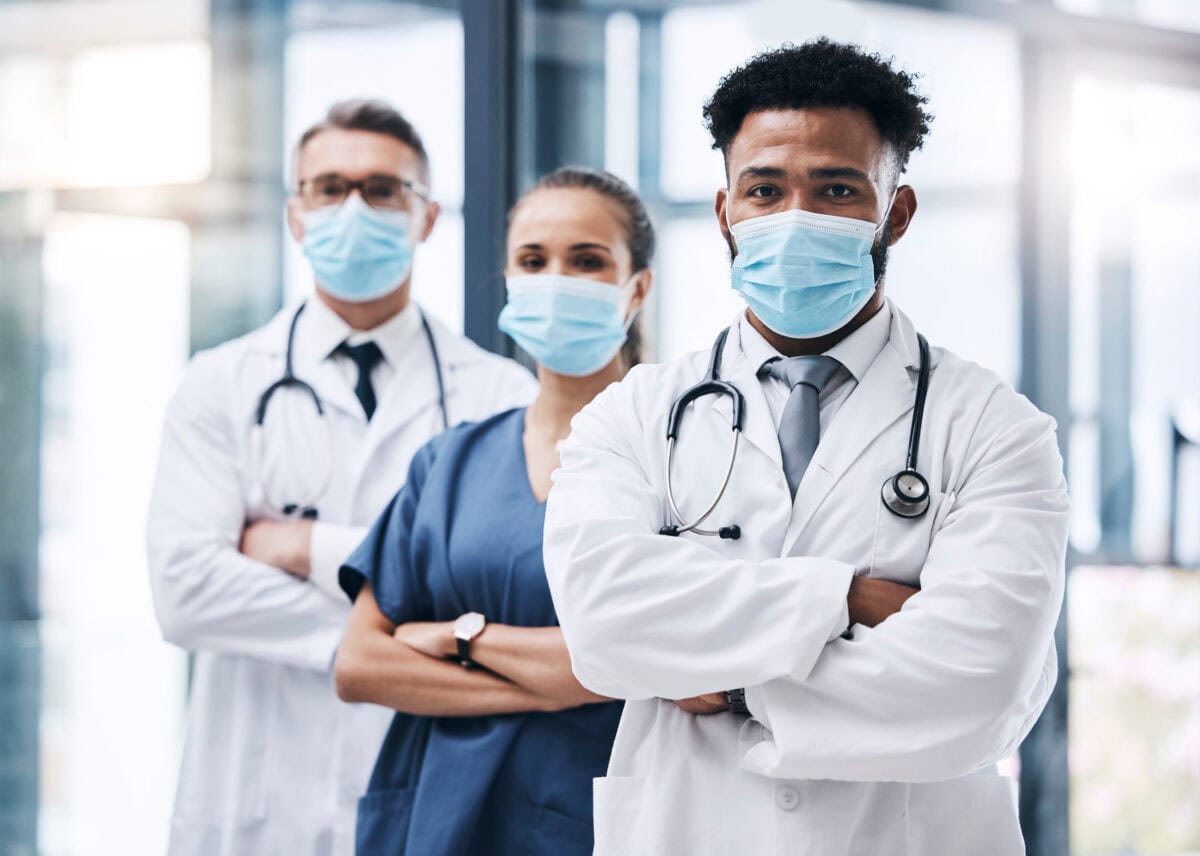 Masque facial, équipe et portrait de médecins debout dans le couloir d'un hôpital. Travail d'équipe, collaboration et groupe d'employés du secteur de la santé prêts pour une consultation dans une clinique.