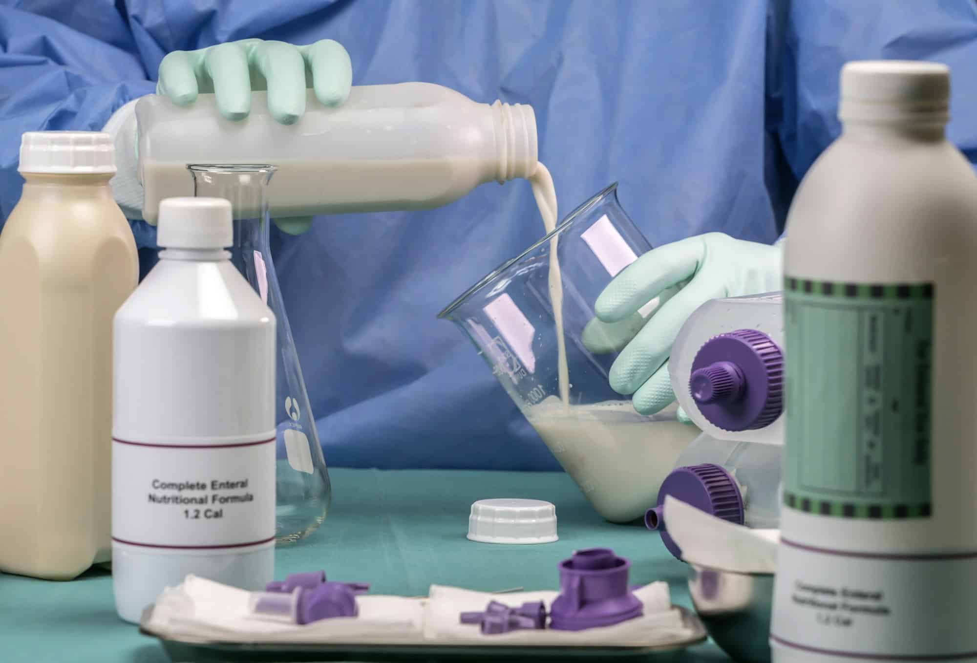 Infirmière remplissant un biberon dans l'équipe de nutrition entérale, soins palliatifs à l'hôpital