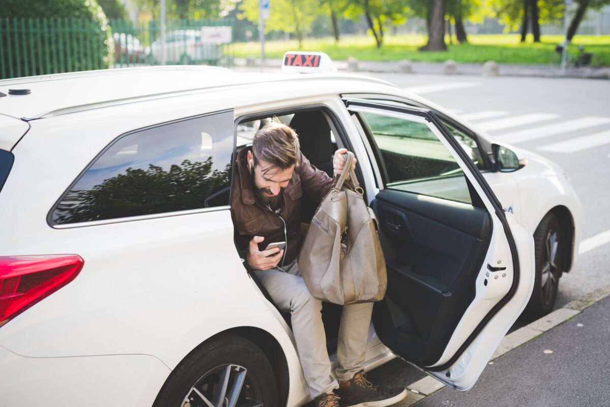 Jeune homme barbu prenant un taxi