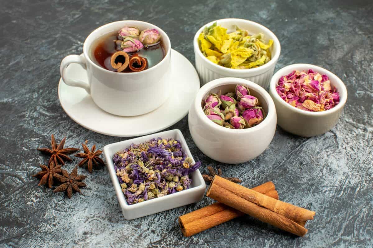 prise de vue latérale d'une tisane avec des fleurs sèches sur fond gris