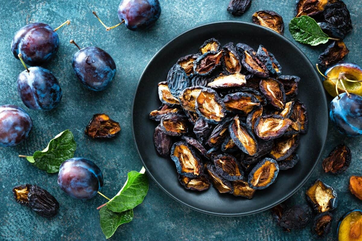 Pruneaux séchés et prunes fraîches avec feuilles