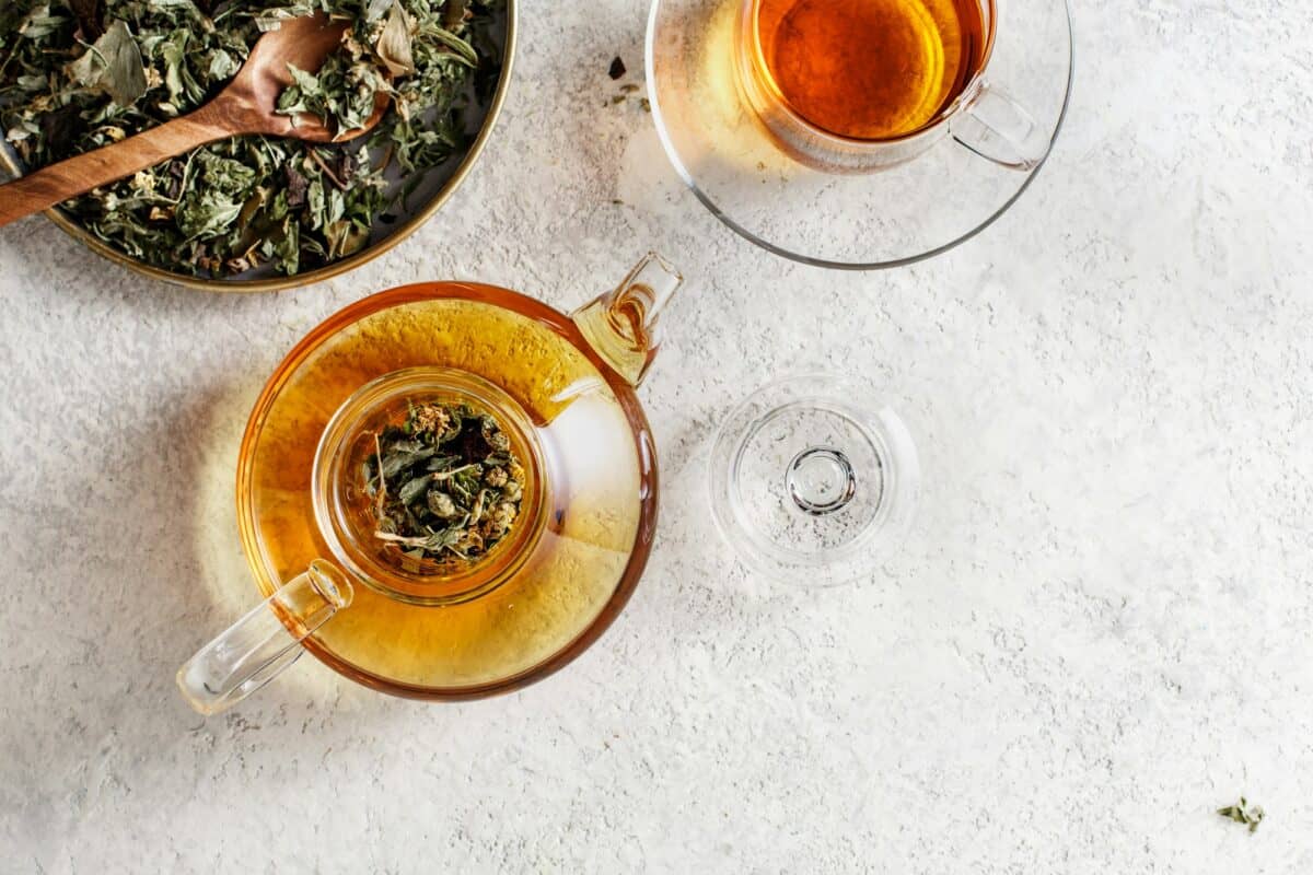 Théière en verre et tasse à thé avec tisane
