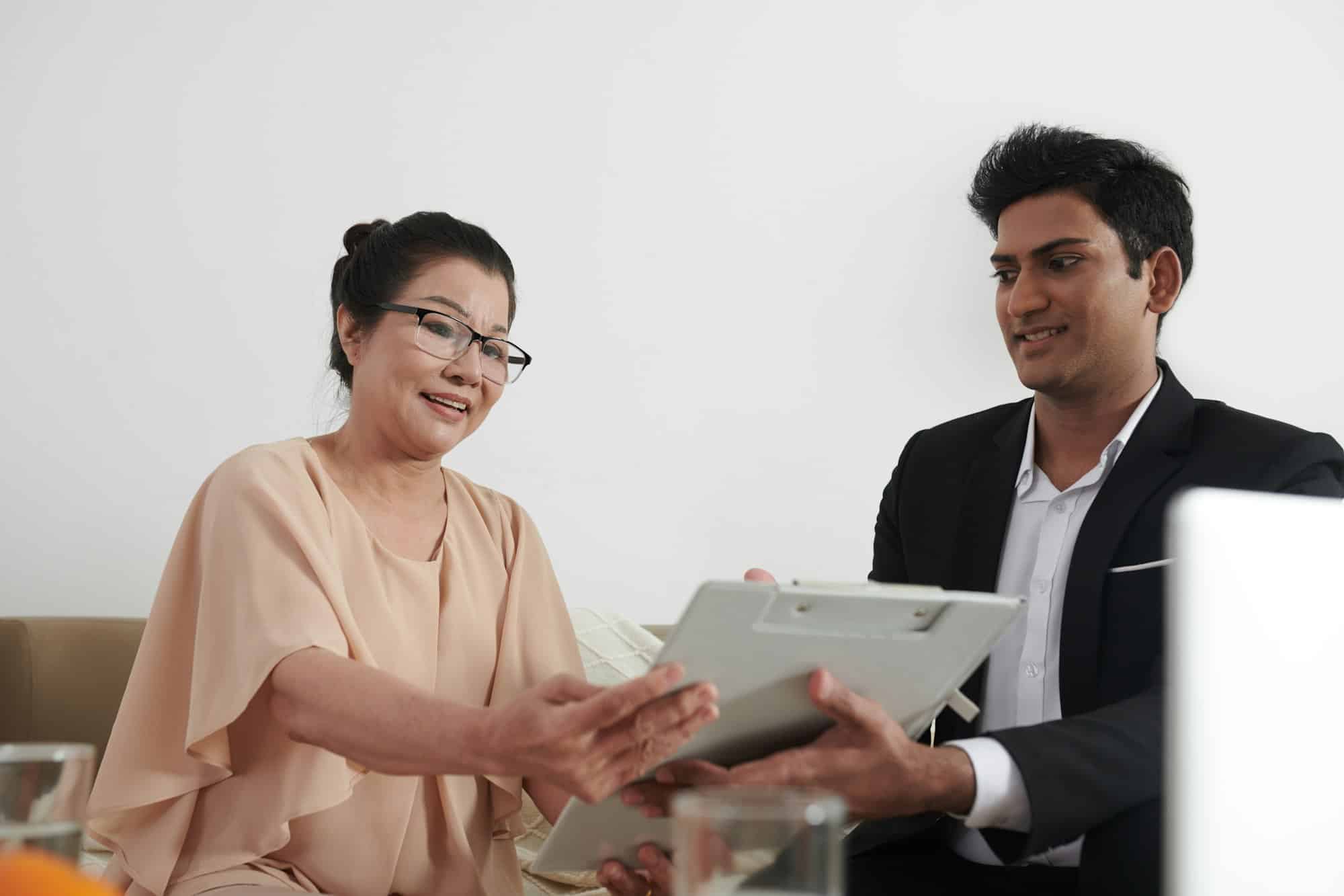 Un agent d'assurance aide un client âgé