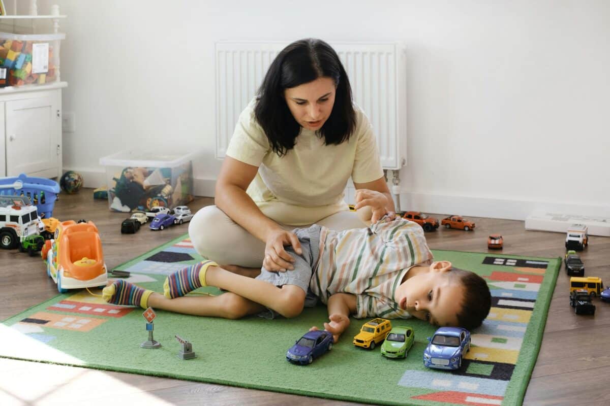 Un enfant atteint de paralysie cérébrale s'amuse avec des jouets, rééducation à domicile