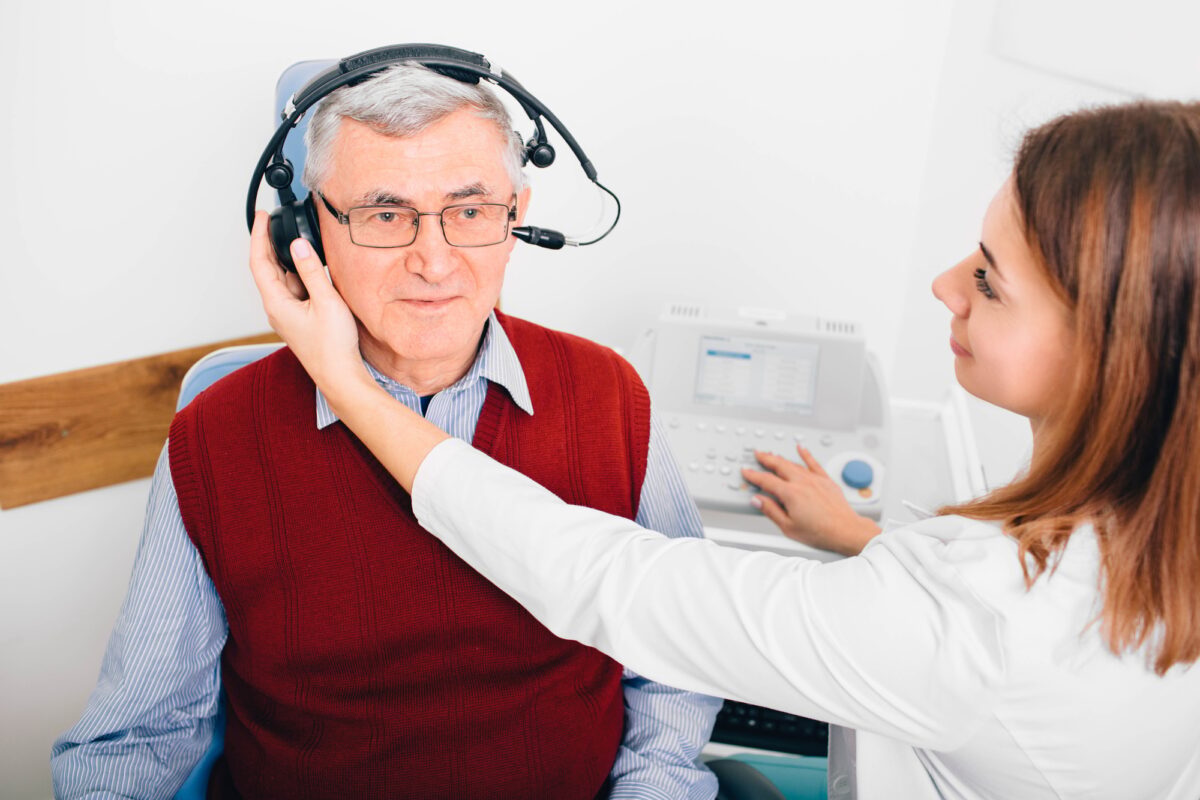 Senior man having hearing exam with special headphones
