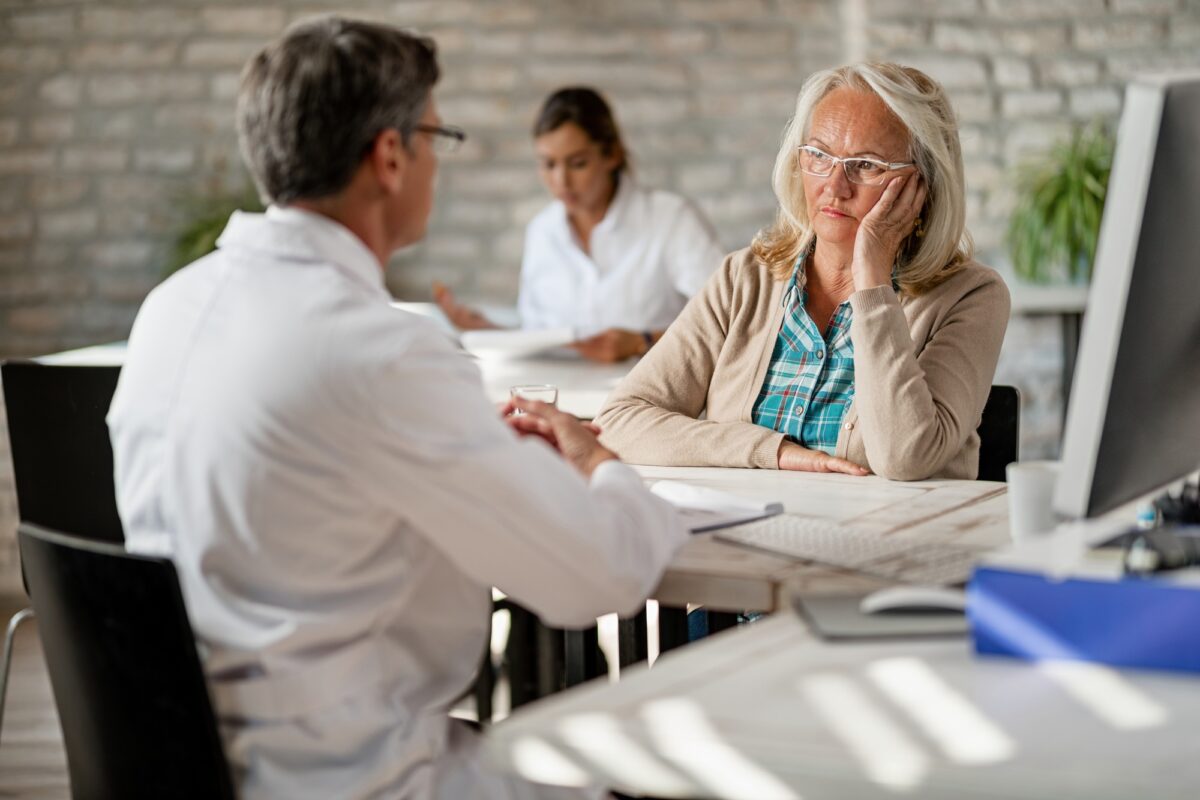 Une femme âgée consulte un médecin au sujet des possibilités d'assurance maladie.