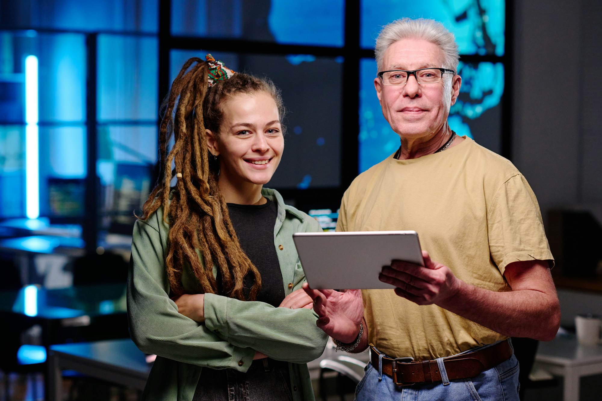 Young woman and her senior male colleague looking at camera
